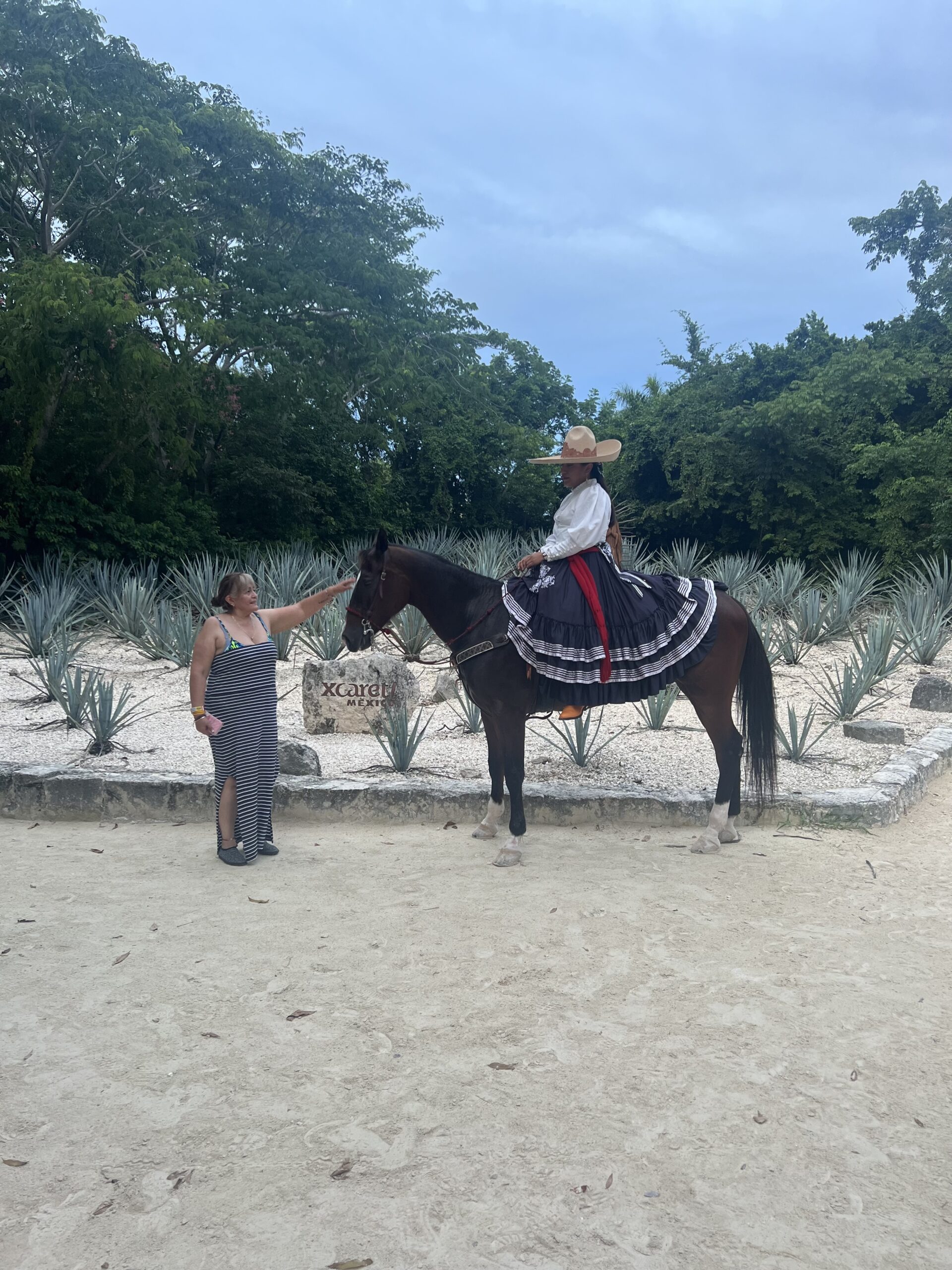 Una escaramuza de Xcaret dejando tocar su caballo.